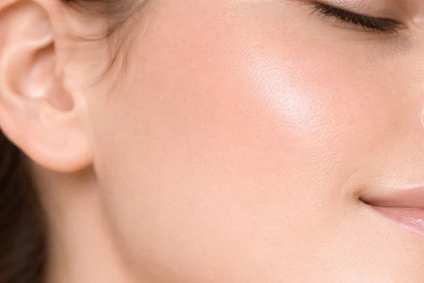 Dettaglio di pelle femminile in luce morbida che evidenzia compattezza, luminosità e qualità cutanea.