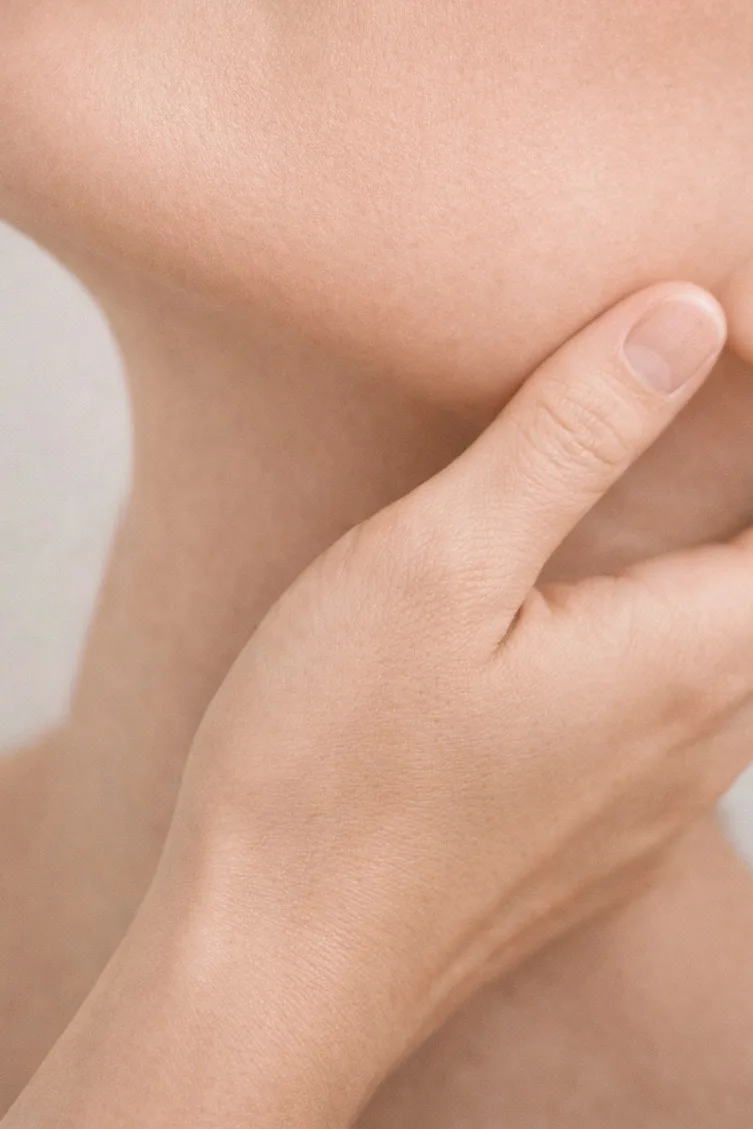 Particolare della zona collo-décolleté con mano in appoggio, rappresentazione di trattamenti mirati alla compattezza e alla qualità della pelle.